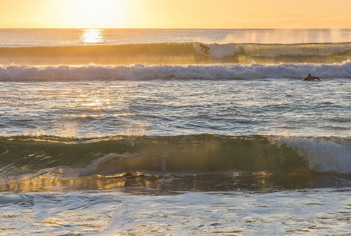 Sunlight on water and surfer-photo by Alan Johnston for article by Dr Anne Malatt on Taking a Break