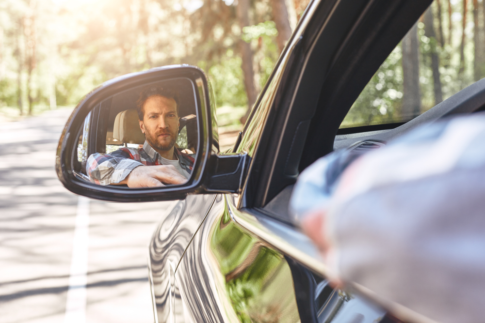 Man looking in blind spot mirror for article on blind spots by Dr Anne Malatt